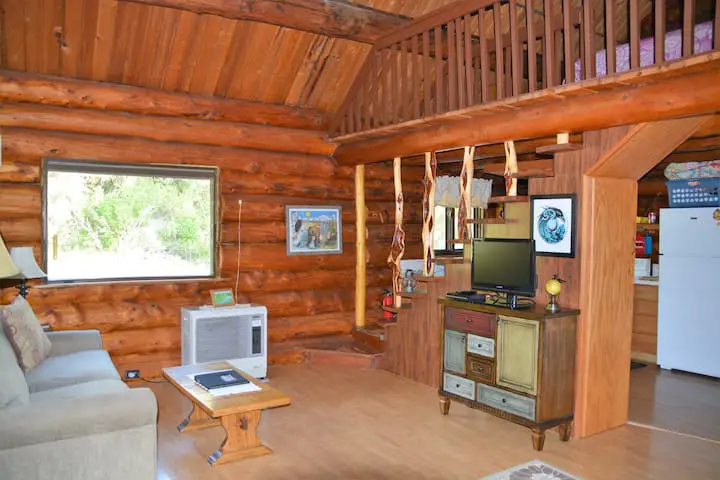 View of living room from the front door. The kitchen is behind the stairs and to the right and the queen bedroom is upstairs.